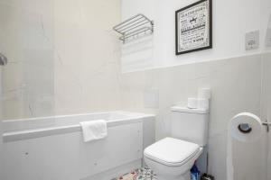 a white bathroom with a toilet and a bath tub at Contemporary 1 Bedroom Apartment in Central Woking in Woking