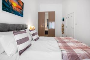 ein Schlafzimmer mit einem großen weißen Bett mit Kissen in der Unterkunft Contemporary 1 Bedroom Apartment in Central Woking in Woking