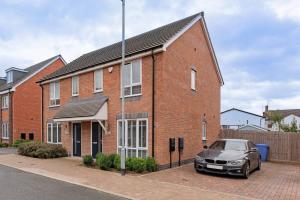 a brick house with a car parked in front of it at Modern 1 Bedroom House in Burton-on-Trent in Burton upon Trent
