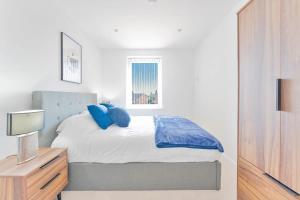 a bedroom with a bed with blue pillows on it at Spacious 2 Bedroom Apartment in Birmingham in Birmingham