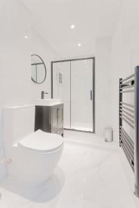 a white bathroom with a toilet and a sink at Spacious 2 Bedroom Apartment in Birmingham in Birmingham