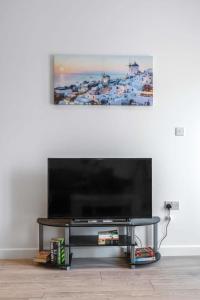 a flat screen tv sitting on top of a table at Lovely 1 Bedroom Apartment in Central Woking in Woking