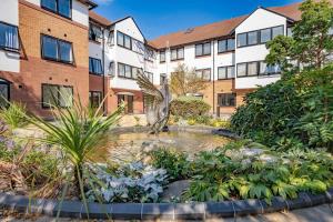 a garden with a fountain in front of a building at Spacious 2 Bedroom Apartment in Birmingham in Birmingham