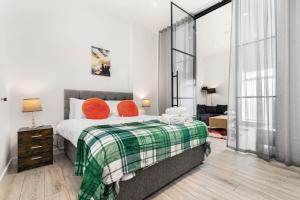 um quarto com uma cama com almofadas laranja em Lovely 1 Bedroom Apartment in Woking Centre em Woking