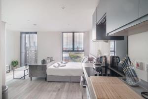 a kitchen with a bed in a room with windows at Spacious Studio in Central Liverpool in Liverpool