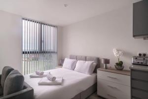 a bedroom with a bed with towels on it at Spacious Studio in Central Liverpool in Liverpool