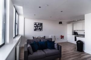 a living room with a couch and a kitchen at Bright & Modern 1 Bed Apartment by Old Trafford in Manchester