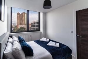 a bedroom with a bed with two towels on it at Bright & Modern 1 Bed Apartment by Old Trafford in Manchester