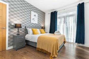 a bedroom with a bed and a window with blue curtains at Spacious 1 Bedroom Apartment in Central Woking in Woking