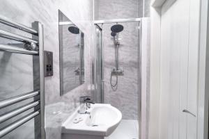 a white bathroom with a sink and a shower at Spacious 3 Bed Apartment in Waterloo Liverpool in Waterloo
