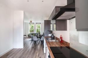 a kitchen with a sink and a table with chairs at Spacious 3 Bed Apartment in Waterloo Liverpool in Waterloo