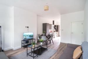 een woonkamer met een bank en een tafel bij Spacious 3 Bed Apartment in Waterloo Liverpool in Waterloo