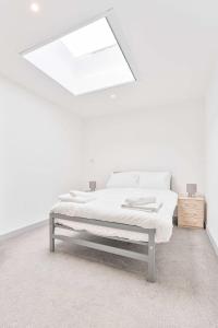 a white bedroom with a bed and a skylight at Modern and Bright 1 Bed Apartment in Dudley in Brierley Hill
