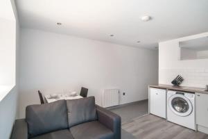 uma sala de estar com um sofá e uma máquina de lavar roupa em Cosy 1 Bed Apartment in Central Blackburn em Blackburn