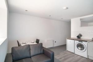 a living room with a couch and a washing machine at Cosy 1 Bed Apartment in Central Blackburn in Blackburn