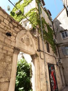 a stone building with a door and ivy at Top Center in Split