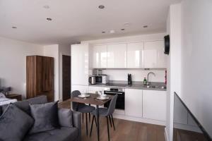 a kitchen and living room with a couch and a table at Cosy Studio Apartment by Old Trafford in Manchester