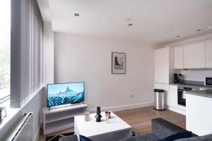 - un salon blanc avec une télévision murale dans l'établissement Stay Zeni, Alexandra Rise Manchester Smart Studio, à Manchester 8 autres photos