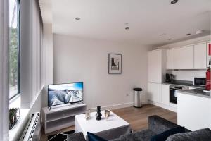 - un salon blanc avec une télévision murale dans l'établissement Stay Zeni, Alexandra Rise Manchester Smart Studio, à Manchester
