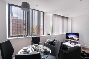 sala de estar con mesa, sillas y TV en Fantastic Studio Apartment by Old Trafford en Mánchester