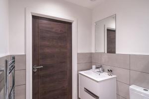 a bathroom with a wooden door and a sink at Charming 1 Bed Apartment in Old Trafford in Manchester