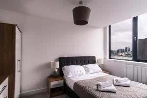 a bedroom with a bed and a large window at Charming 1 Bed Apartment in Old Trafford in Manchester