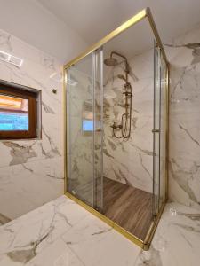 y baño con ducha y puerta de cristal. en Rita Luxury Ranch, en Gospić