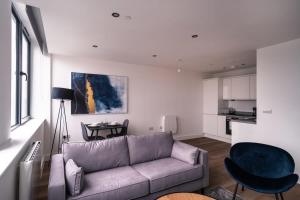 ein Wohnzimmer mit einem Sofa und einem Tisch in der Unterkunft Charming 1 Bed Apartment in Old Trafford in Manchester