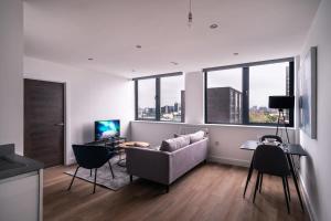 a living room with a couch and a table with chairs at Charming 1 Bed Apartment in Old Trafford in Manchester