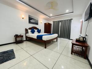 a bedroom with a bed with blue pillows on it at Tattvam Wild Ocean in Arambol