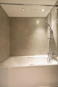 a bathroom with a shower and a white tub at Modern 1 Bedroom Apartment in Crawley in Crawley