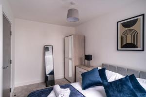 - une chambre avec un lit et des oreillers bleus dans l'établissement Lovely 1 Bedroom Apartment in Old Trafford, à Manchester