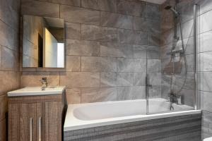 a bathroom with a tub and a sink and a mirror at Budget 1 Bed Apartment in Central Doncaster in Doncaster