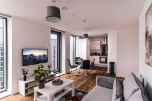 2 Bed Apartment in Media City, Amazing Views في مانشستر: غرفة معيشة مع أريكة وطاولة