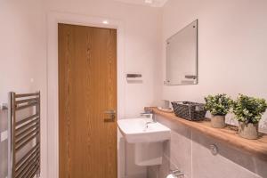 a bathroom with a sink and a mirror at 2 Bed Apartment in Media City, Amazing Views in Manchester