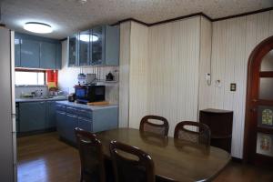 una cucina con tavolo e sedie in una cucina di 上田屋　半田館 a Handa