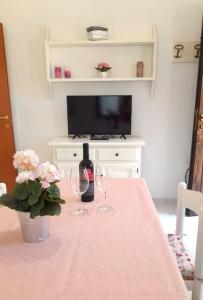 a table with two glasses and a bottle of wine at Ferienhaus Casa Geranio - Villaggio Galanu in Costa Paradiso +15 photos