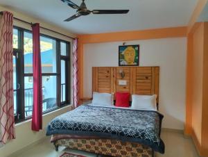 1 dormitorio con 1 cama con 2 almohadas rojas en Aman Inn, en Dharamshala