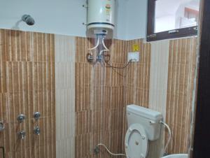een badkamer met een toilet en een douche bij Aman Inn in Dharamshala