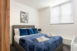 a bedroom with a bed with two towels on it at Smart 1 Bedroom Apartment in Leeds in Leeds