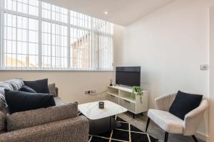 a living room with a couch and two chairs and a tv at Modern 2 Bedroom Apartment in Central Hull in Hull