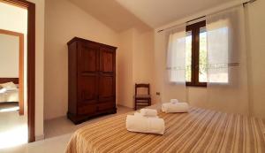 a bedroom with a bed with two towels on it at Ferienhaus Casa Oliva - Villaggio Galanu in Costa Paradiso