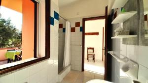 a bathroom with a toilet and a view of a patio at Ferienhaus Casa Oliva - Villaggio Galanu in Costa Paradiso
