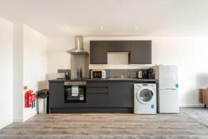 a kitchen with a washing machine and a washer at Stylish 1 Bed Apartment in Central Retford in Retford