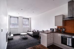 a kitchen and living room with a couch and a table at Lovely 1 Bed Apartment in Central Blackburn in Blackburn