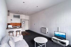 sala de estar con sofá, mesa y cocina en Lovely 1 Bed Apartment in Central Blackburn en Blackburn