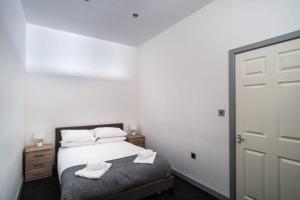 a bedroom with a bed with two towels on it at Lovely 1 Bed Apartment in Central Blackburn in Blackburn