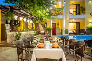a table with plates of food on it in a restaurant at Ohana Hoian Villa in Hoi An