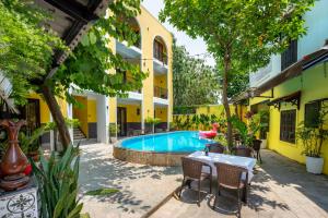 a patio with a table and chairs and a swimming pool at Villa Ohana Gadren by Cocoviet Hoi An in Hoi An