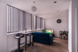 a living room with a blue couch and a table at Modern Studio Apartment near Old Trafford in Manchester